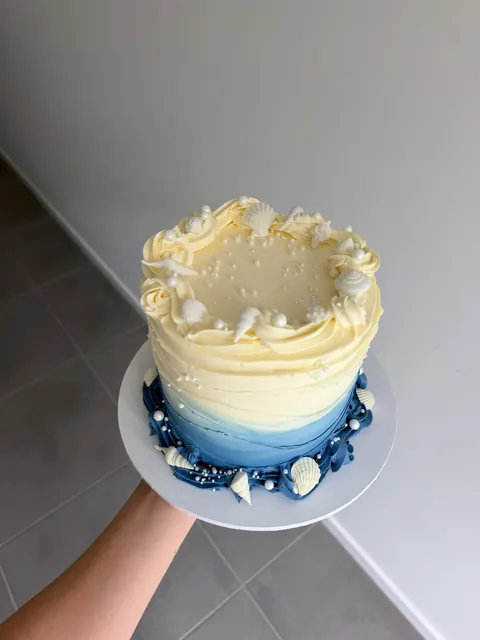 Lemon and navy ombre buttercream cake with white seashells and pearls