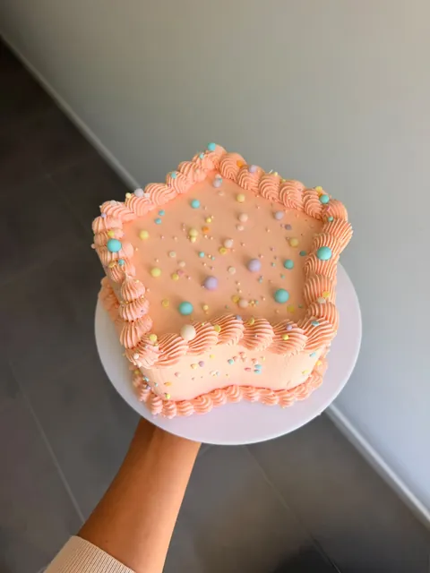 Peach star-shaped cake with vintage piped borders and pastel sprinkles