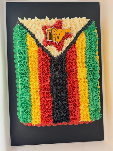 Rectangular slab cake piped as the Zimbabwe flag in green, yellow, red and black stars of buttercream